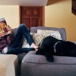Persona descansando en casa junto a su perro